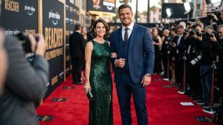 Alan Ritchson and Catherine Ritchson posing together on a red carpet premiere